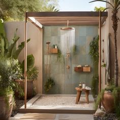 an outdoor shower with plants and potted trees in the background, along with a bench