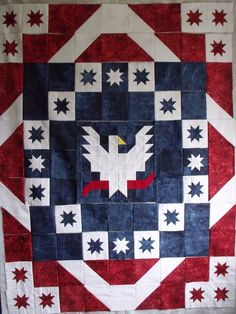 a quilted wall hanging with an eagle and stars design on the front, in red white and blue