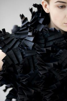 a woman in black dress with lots of ruffles on her arms