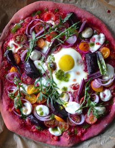 a pizza topped with an egg and veggies