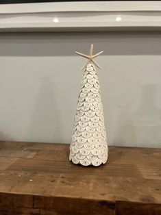 a small white christmas tree on top of a wooden table