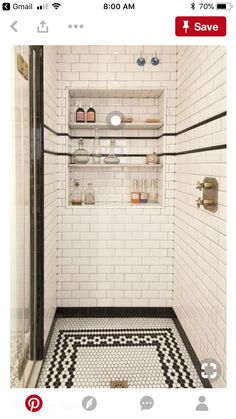 a white tiled bathroom with black and white floor tiles on the shower wall, shelves in the corner