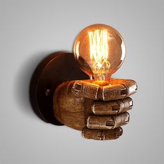 a wooden hand holding a light bulb on top of it