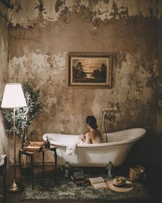 a woman sitting in a bathtub surrounded by books