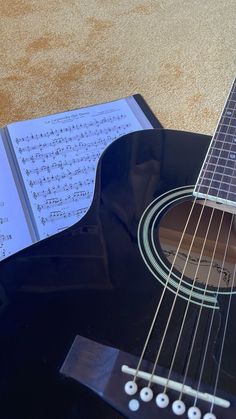 an acoustic guitar with sheet music on it