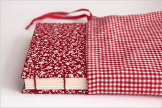 a red and white checkered book with a ribbon on the cover is laying open