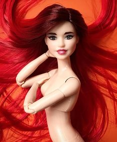 a doll with long red hair laying on top of it's head and body