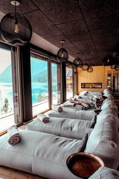 a row of couches sitting next to each other in front of large windows with ocean view