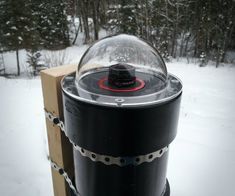 a large black object sitting on top of a snow covered ground