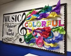 a colorful bulletin board with music notes and paper streamers on the wall in front of it