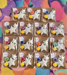 six boxes with different colored buttons on them sitting on a table in front of a colorful wall