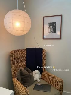 a wicker chair with a laptop on it in front of a white light fixture