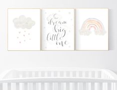 three nursery prints featuring clouds, rainbows and stars are hanging on the wall next to a crib