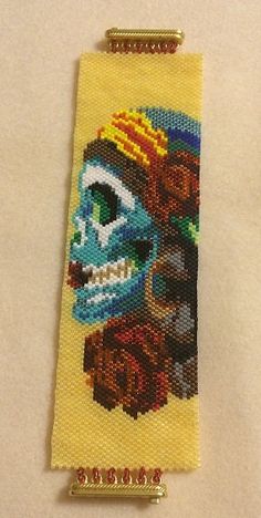 a cross stitch bookmark with an image of a skull on it