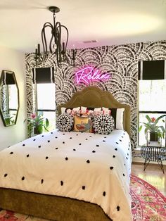 a bedroom with black and white wallpaper, pink accents and a bed in the middle