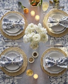 the table is set with blue and white plates, silverware, and napkins