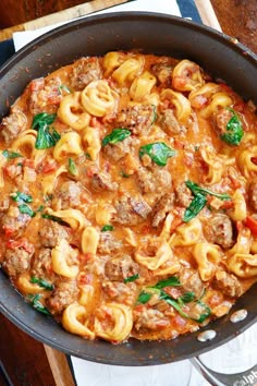 a skillet filled with pasta and meat