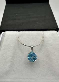 This 6mm round SWISS BLUE TOPAZ pendant is hand set in a sterling silver vintage inspired scroll pendant mounting. The pendant can come with a 0.7mm sterling silver snake chain or not - it's your choice.  Topaz is the birthstone of December, has been popularly associated with wealth and can make a great Valentine's Day present.  This pendant ships with its own gift box. Metal: .925 Sterling Silver Gemstone:  Swiss Blue Topaz Color:  Blue Stone Shape: Round Grade:  Loupe Clean Stone Weight:  Appr Blue Diamond Cut Necklace In Sterling Silver, Round Pendant Jewelry With Bail For Anniversary, Blue Diamond Cut Round Cut Necklaces, Fine Jewelry Hallmarked Necklaces With Round Stone, Hallmarked Sapphire Round Pendant Necklace, Blue Round Sterling Silver Jewelry, Blue Round Fine Jewelry Necklace, Blue Round Hallmarked Jewelry, Blue Round Pendant Jewelry For Anniversary