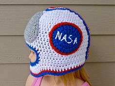 a woman wearing a crocheted hat with the word nasa written in white and blue