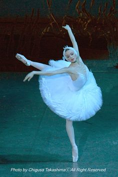 the ballerina is dressed in white and dancing