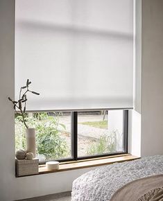 a bedroom window with white blinds in it