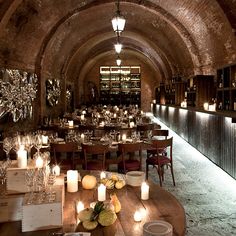 an empty restaurant with candles and wine glasses on the table in front of it's walls