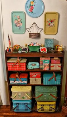 a shelf filled with lots of different colored boxes on top of wooden floor next to a white wall