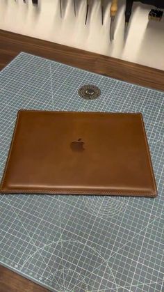 an apple computer sitting on top of a table next to a knife and tool holder