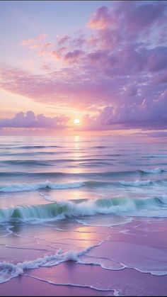 the sun is setting over the ocean with waves coming in to shore and pink clouds