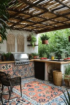 Outdoor kitchen with a patterned tile countertop, a built-in grill, and hanging plants under a wooden pergola. Small Outdoor Kitchen Design, Small Outdoor Kitchen, Small Outdoor Kitchens