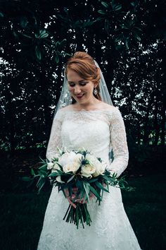 a woman in a wedding dress holding a bouquet