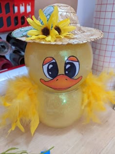 a yellow duck with a straw hat on it's head sitting on a table