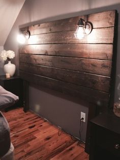 a bed with wooden headboard and two lights on the wall next to each other