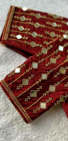 two red and gold embroidered cloths laying on top of each other