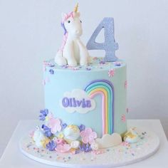 a birthday cake with a unicorn on top and the number four in blue frosting