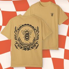 This comfort Colors tee made 100% with ring-spun cotton features a small bee on the front and a framed bee on the back! The soft-washed, garment-dyed fabric brings extra coziness to your wardrobe while the relaxed fit makes it an excellent daily choice. The double-needle stitching throughout the tee makes it highly durable while the lack of side-seams helps the shirt retain its tubular shape.  The Comfort Colors tee is made with medium fabric consisting of high quality, 100% ring-spun US cotton for long-lasting comfort. The relaxed fit keeps the wearer comfy in both casual and semi-formal settings while the crew neckline delivers that classic, neat style which makes it perfect for accessorizing.  The pre-shrunk fabric ensures a consistently great fit.  Made using 100% US cotton that is eth Vintage Cotton T-shirt With Front And Back Print, Vintage Crew Neck Top With Front And Back Print, Vintage Crew Neck T-shirt With Custom Print, Yellow Graphic Tee With Custom Print, Yellow Custom Print Graphic Tee, Graphic Tee With Front And Back Print, Custom Print Graphic Tee, Small Bees, Comfort Colors Tee