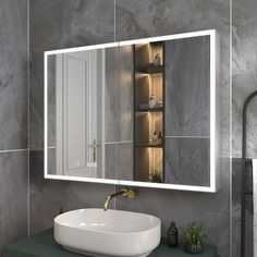 a bathroom sink sitting under a large mirror next to a wall mounted faucet