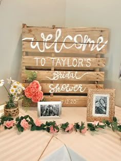 a wooden sign that says welcome to taylor's bridal shower with flowers on the table