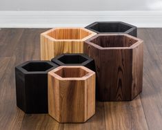 four wooden vases sitting on top of a hard wood floor