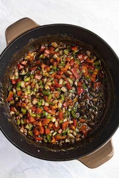 a skillet filled with vegetables on top of a table