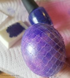 a purple ball sitting on top of a table next to some paint and a brush