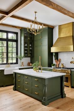 a kitchen with green cabinets, gold accents and a large island in front of the stove