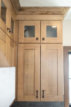 a kitchen with wooden cabinets and black counter tops in front of a window on the wall