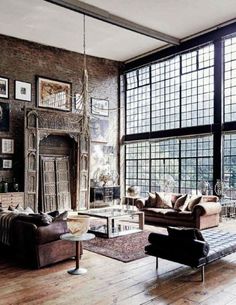 a living room filled with lots of furniture next to a fire place and large windows