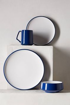 blue and white dishes are stacked on top of each other in this minimalist display