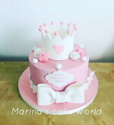 a pink and white cake with a crown on top