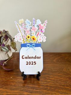 a vase filled with flowers on top of a wooden table