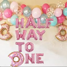 balloons and doughnuts with the words half way to one written in large letters