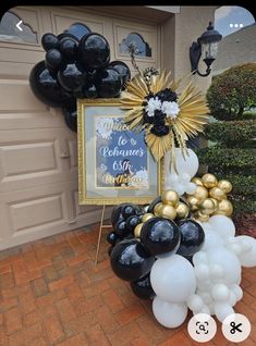 black and white balloons are in front of a house