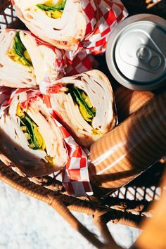 a basket filled with sandwiches next to a can